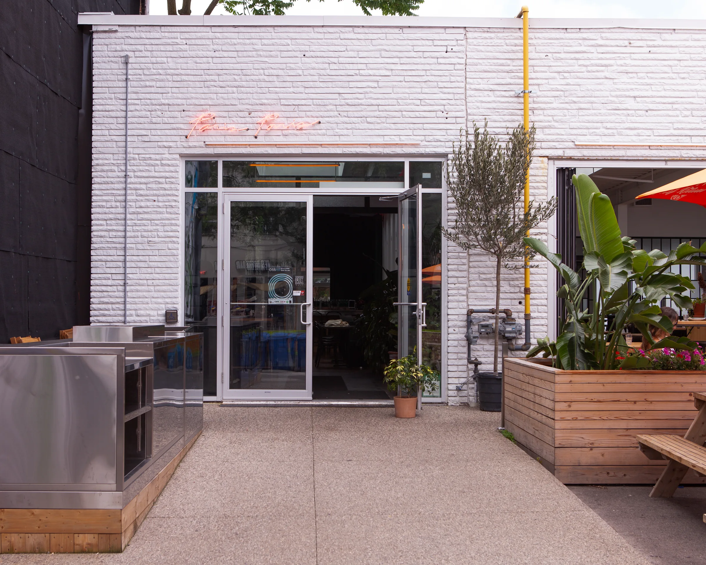 Paris Paris entrance with olive tree and neon signage