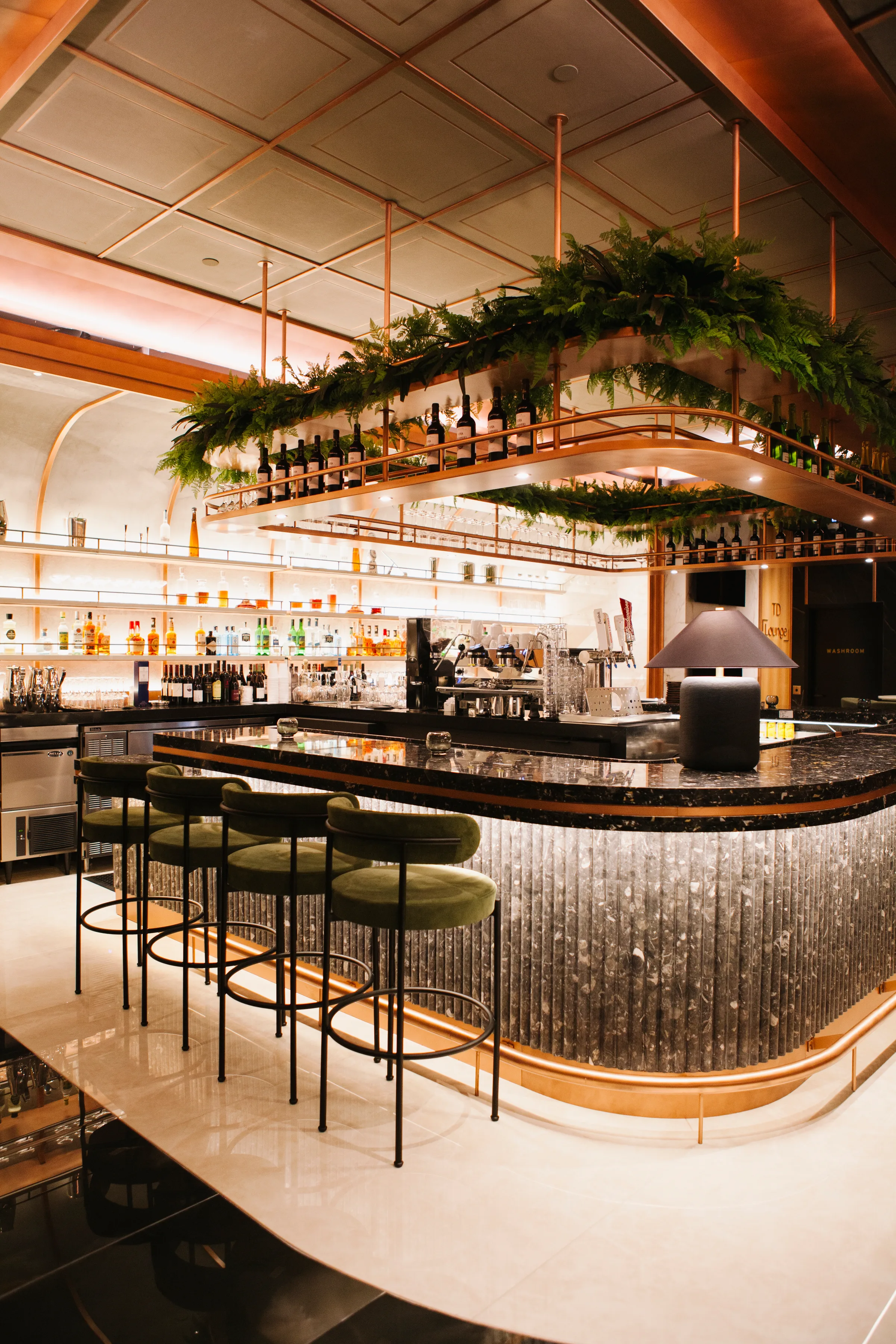 Bar detail with hanging greenery installation and copper accents at Rogers Centre