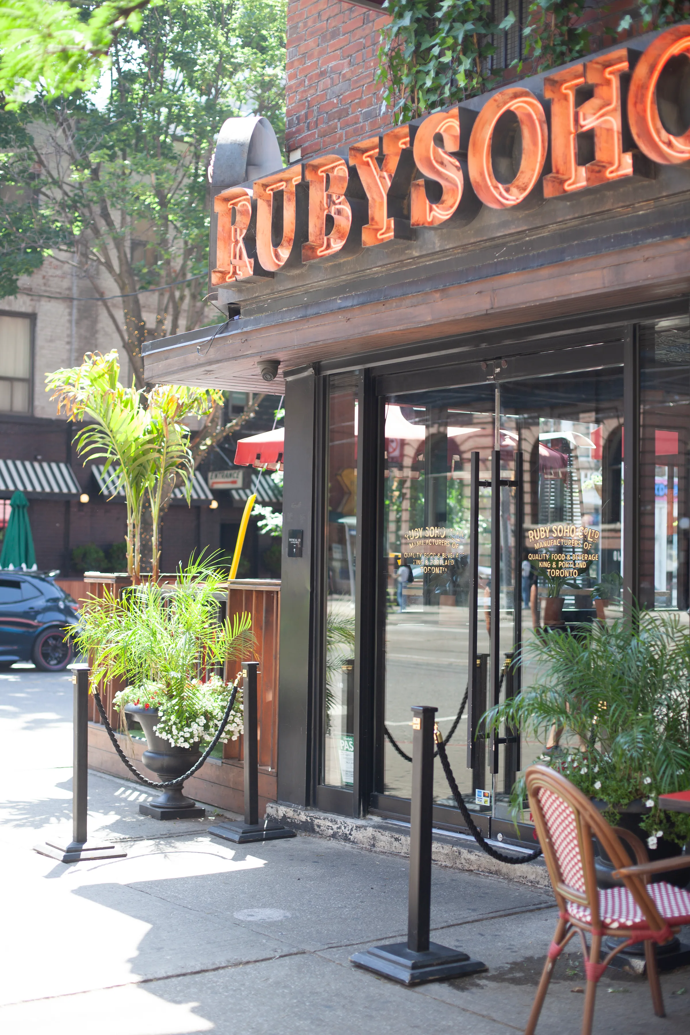 Ruby Soho entrance with RUBYSOHO neon sign and tropical plants